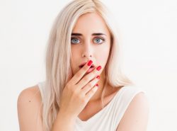 γυναίκα καλύπτει το στόμα της